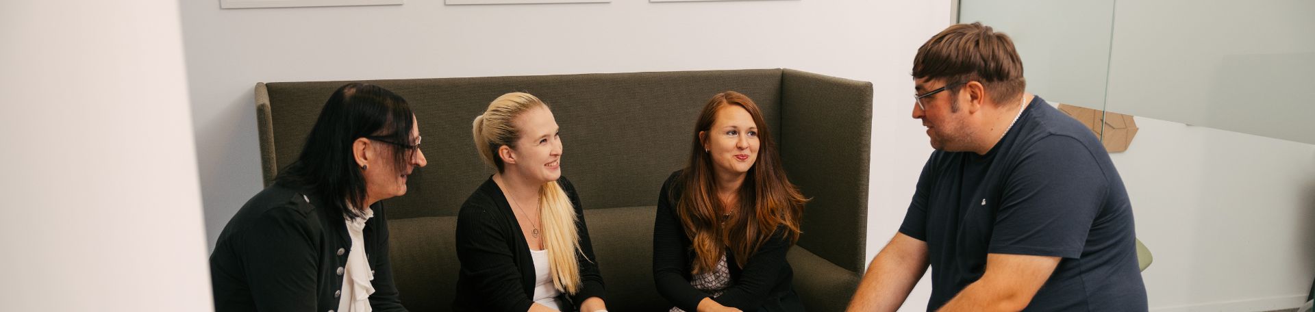 VEDA-Kolleg:innen sitzen in einer Lounge im Leipziger Office zusammen.