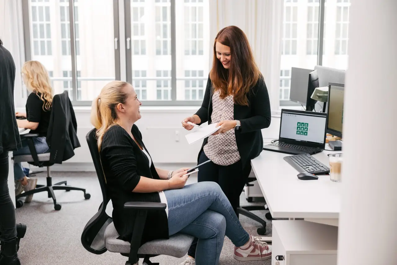 VEDA-Kolleginnen im Leipziger Büro, die gemeinsam ein Thema besprechen.