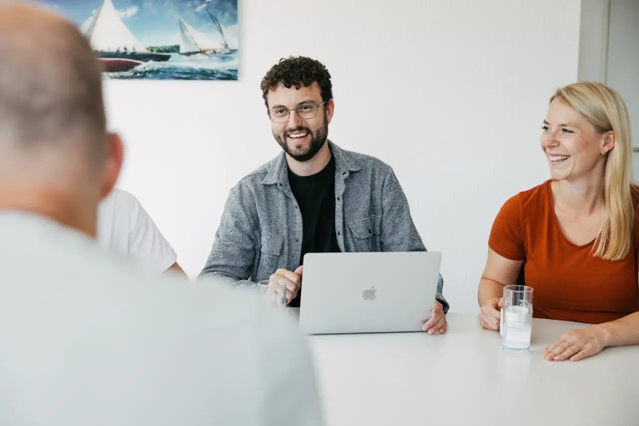 VEDA-Kolleg:innen sitzen gemeinsam am Besprechungstisch und tauschen sich aus.