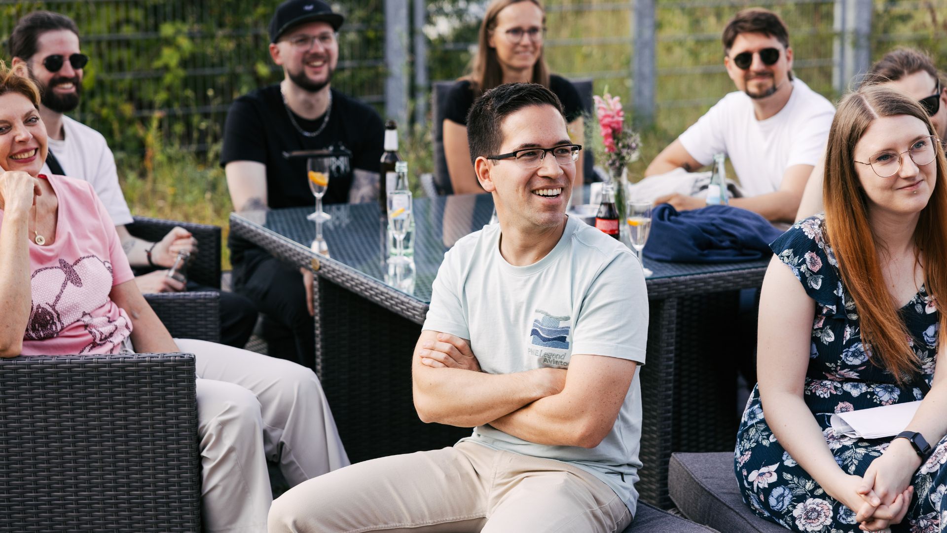 VEDA-Mitarbeiter:innen hören gespannt einer Rede beim Sommerfest 2025 zu.