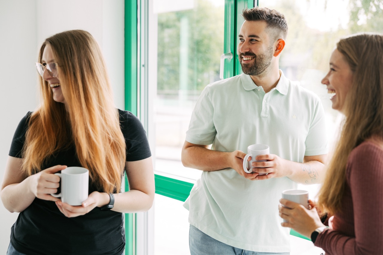Die Recruiting-Ansprechpartner:innen bei VEDA schauen lachend in eine Richtung.