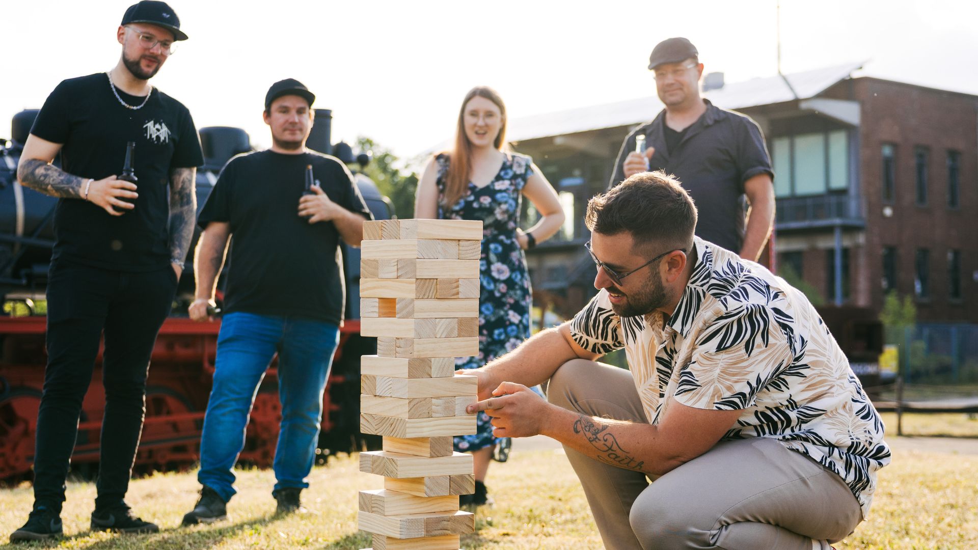 VEDA-Mitarbeiter:innen spielen Outdoor-Jenga auf dem Sommerfest.